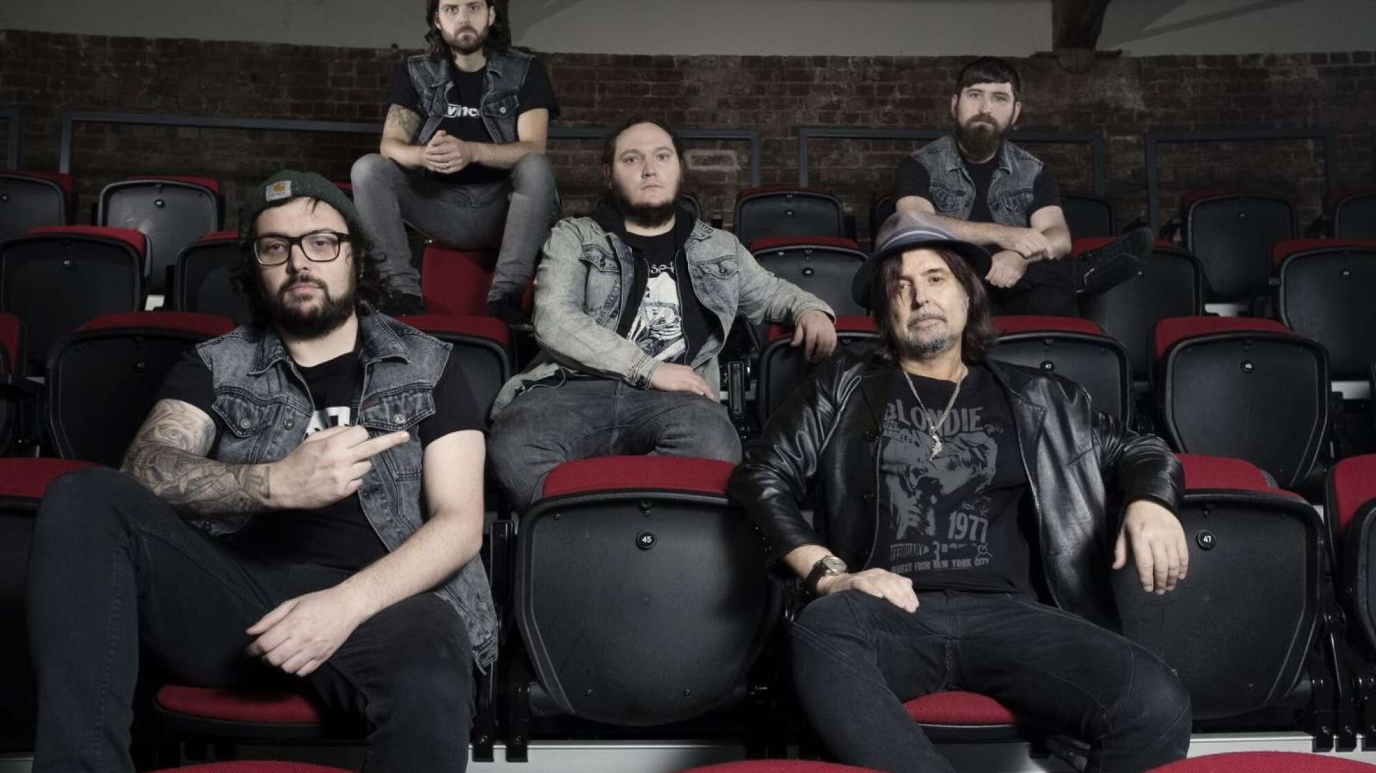 Phil Campbell sitzt mit Musikerkollegen auf Kinositzen
