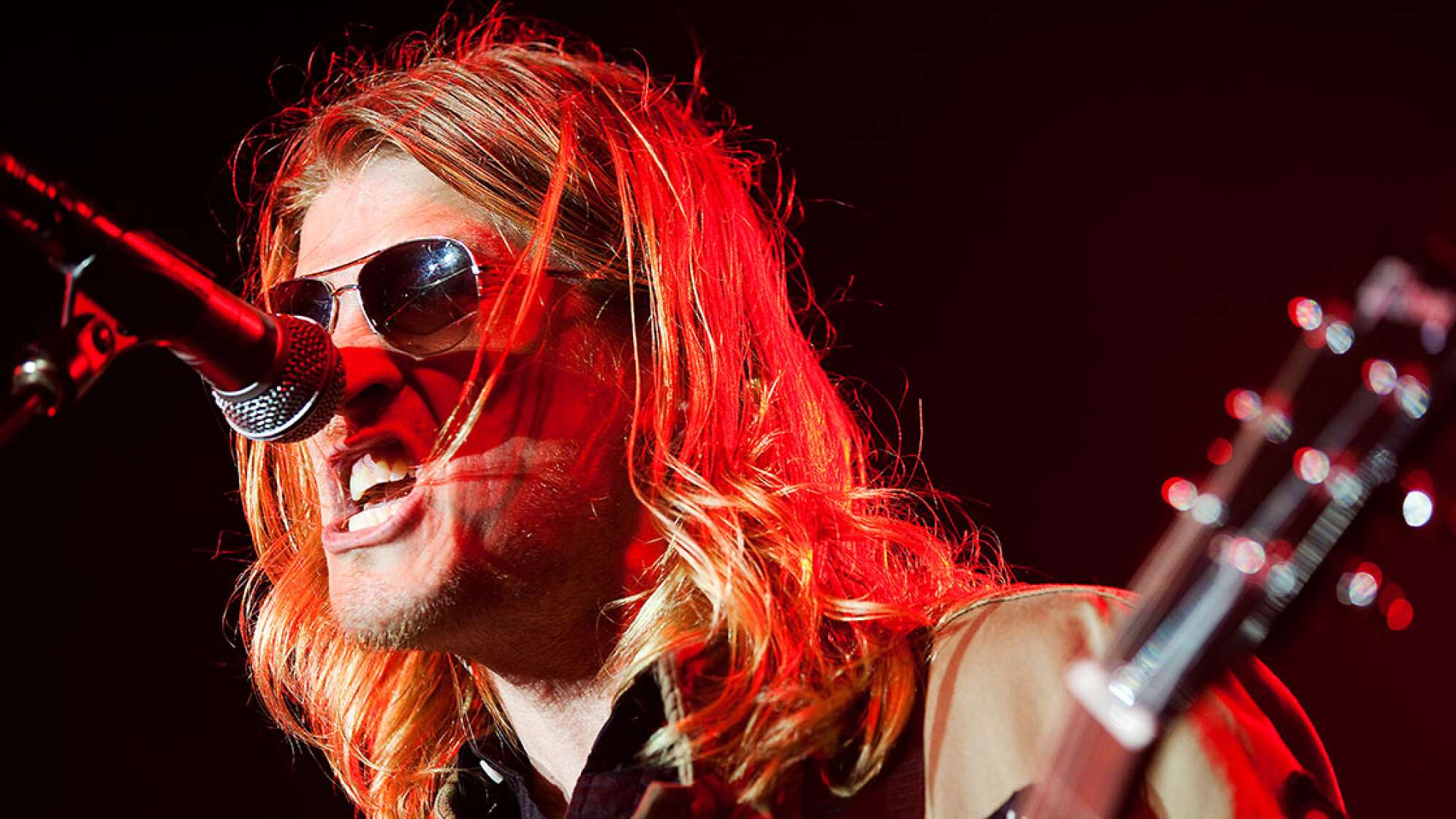 Wes Scantlin trägt eine Sonnenbrille und singt in ein Mikrofon
