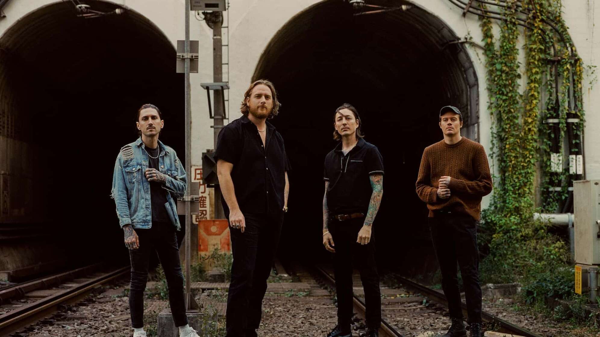 Die Bandmitglieder von The Plot In You stehen vor einem Tunnel und blicken in die Kamera