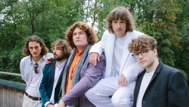 die Bandmitglieder von Cordoba78 auf einem Geländer vor mehreren Bäumen