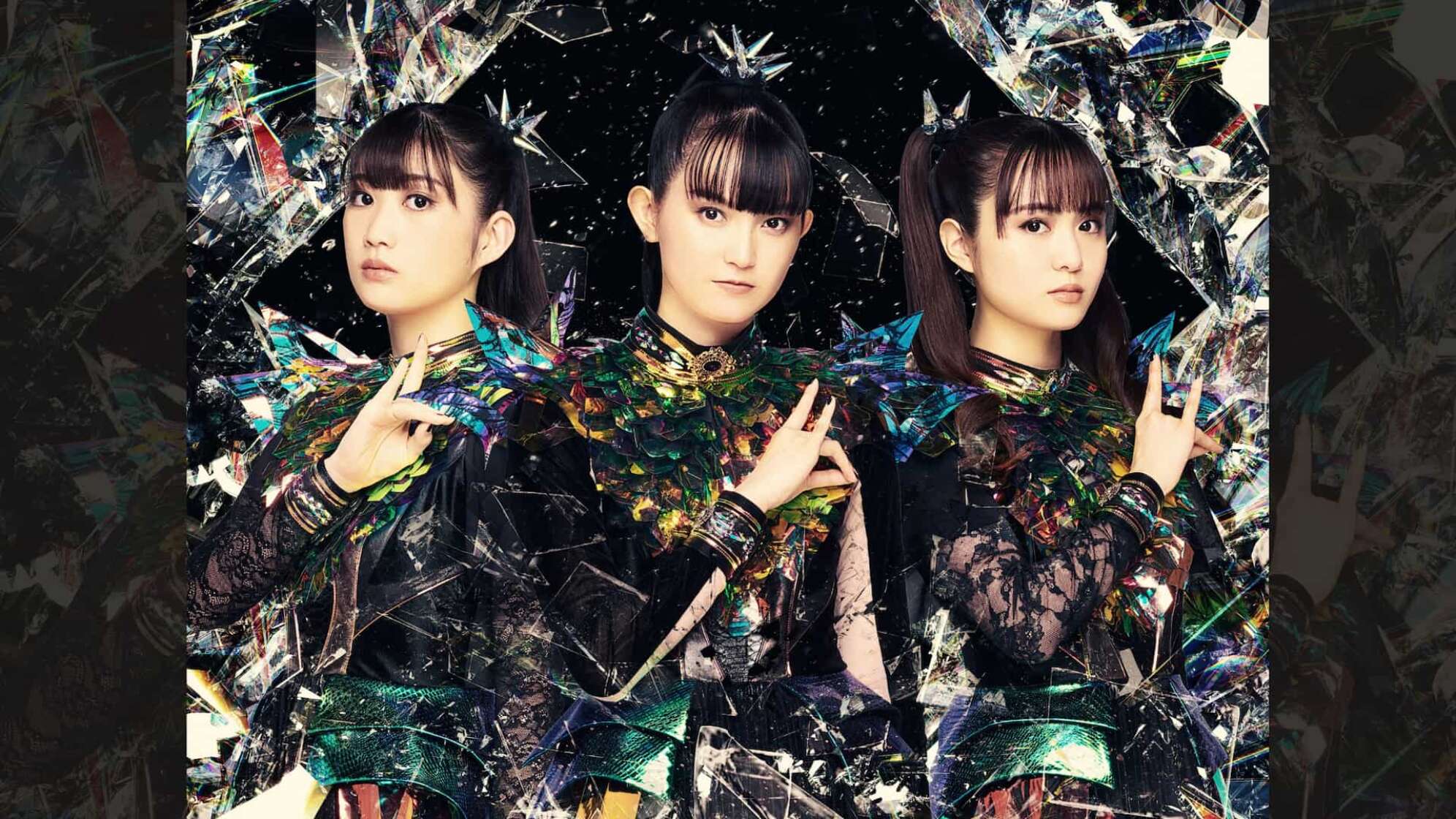 die drei Mitglieder von Babymetal zeigen das Zeichen des Fuchsgottes