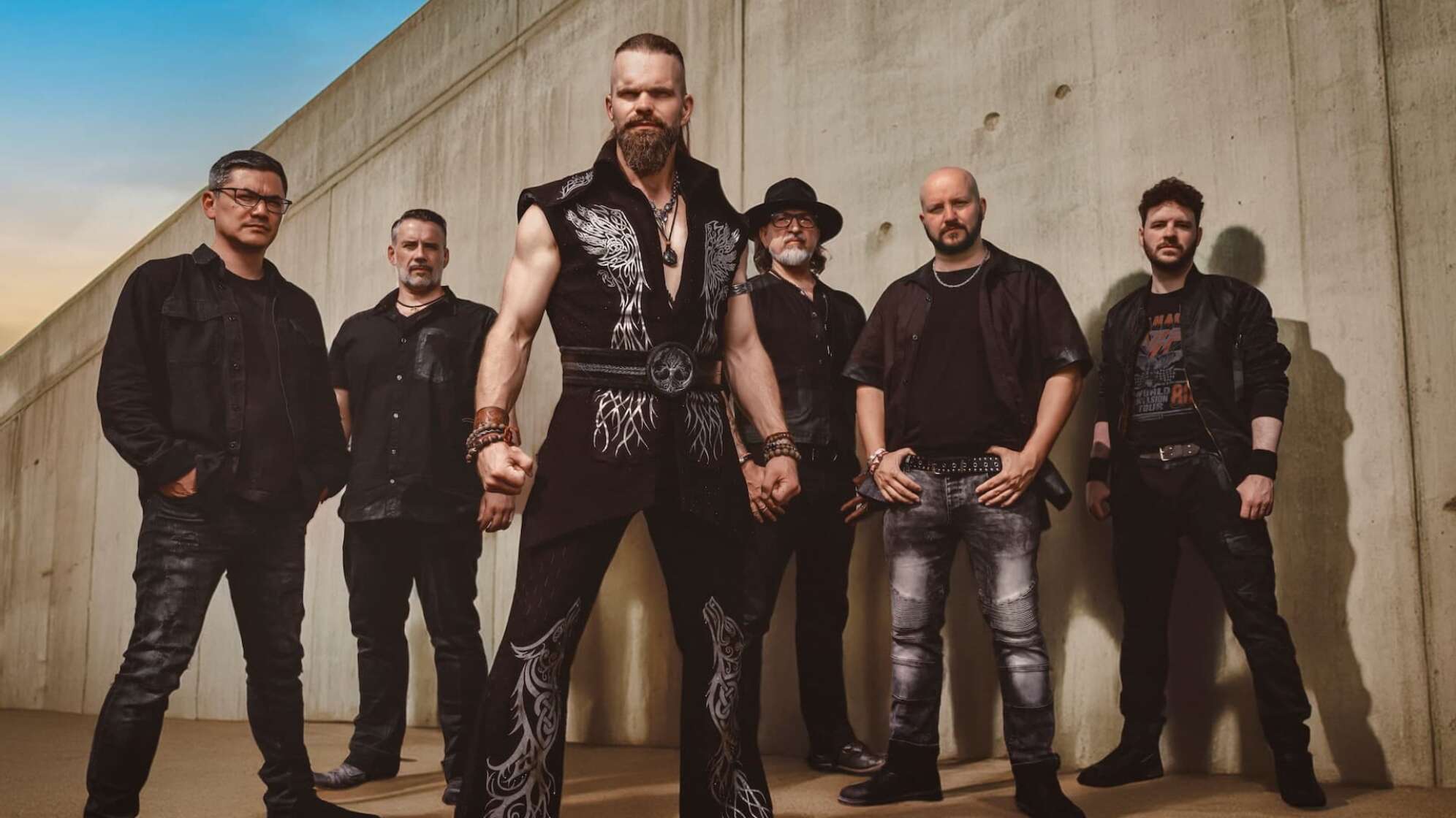 die Bandmitglieder von Saltatio Mortis vor einer Steinwand