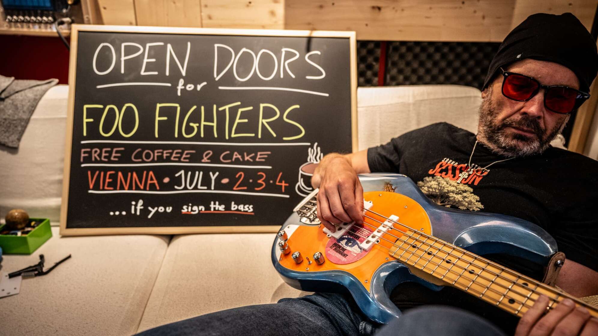 Bassist Martin von den Open Doors sitzt mit einem Bass vor einer Kreidetafel