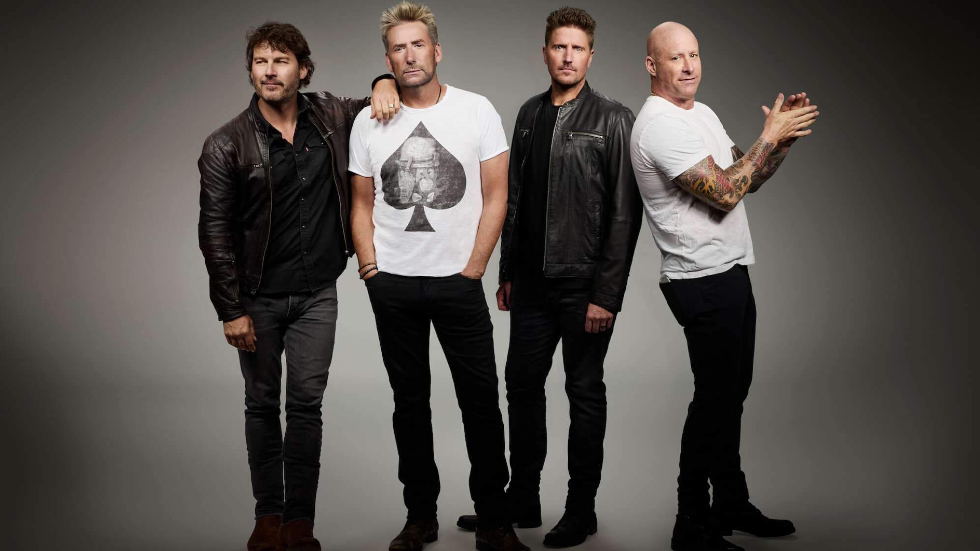 die vier Bandmitglieder von Nickelback stehen vor einem grauen Hintergrund