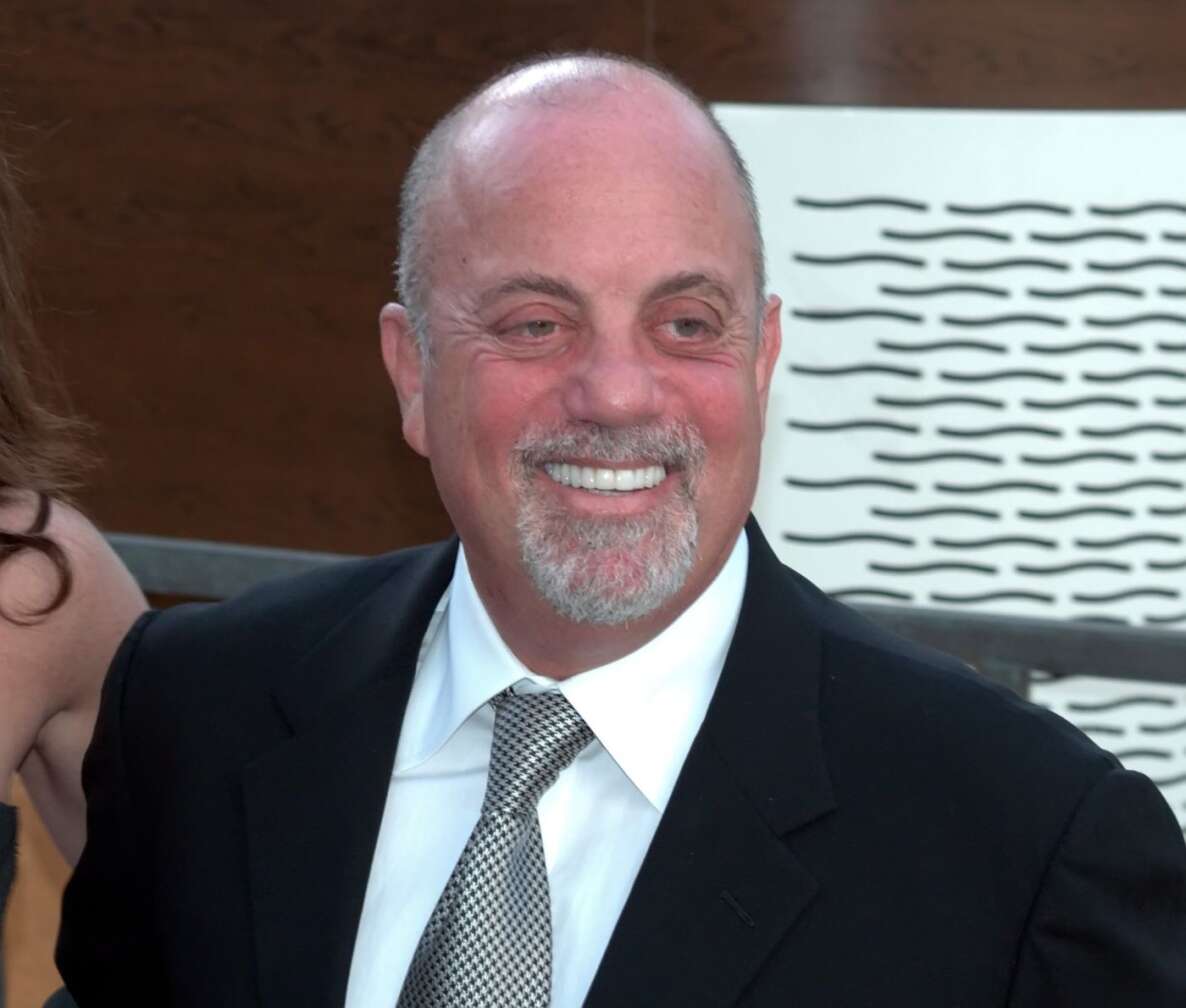 Porträtbild von Billy Joel im Anzug, lächelnd