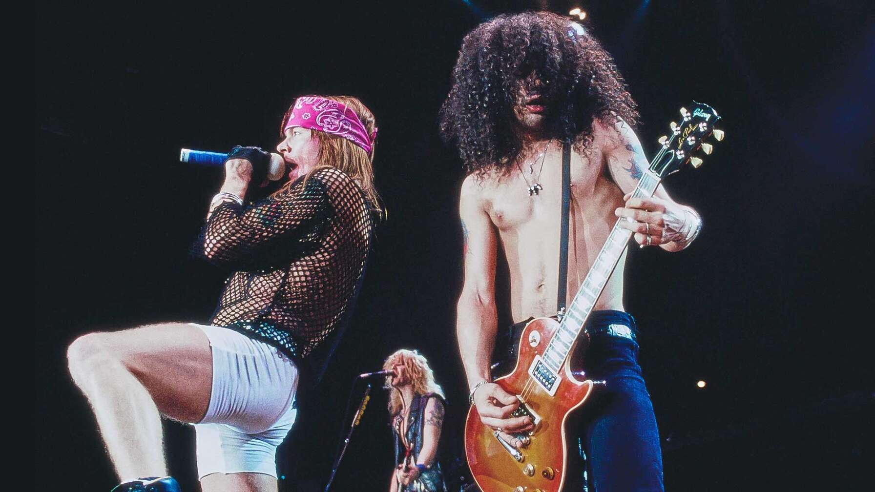 Guns N' Roses bei einer Konzert-Performance - von links nach rechts: Axl Rose, Duff McKagan und Slash.