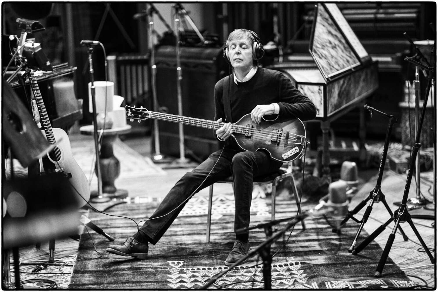 Paul McCartney sitzend, mit Gitarre, bei Studioaufnahmen