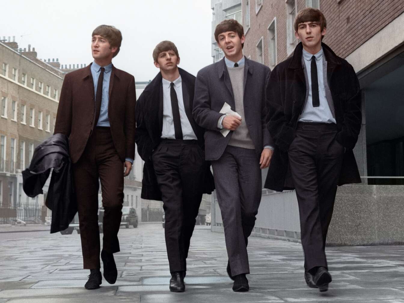 Beatles laufen nebeneinander eine Straße entlang