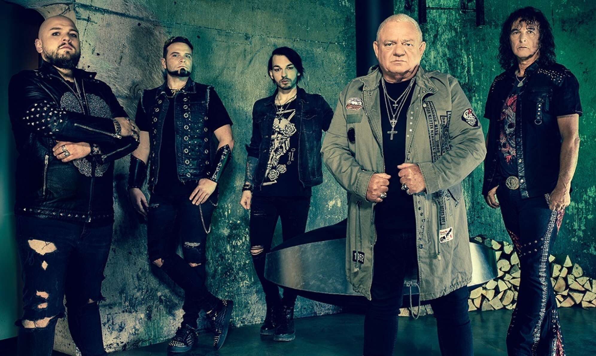 Bandfoto der deutschen Band U.D.O. vor grünem Hintergrund Querformat