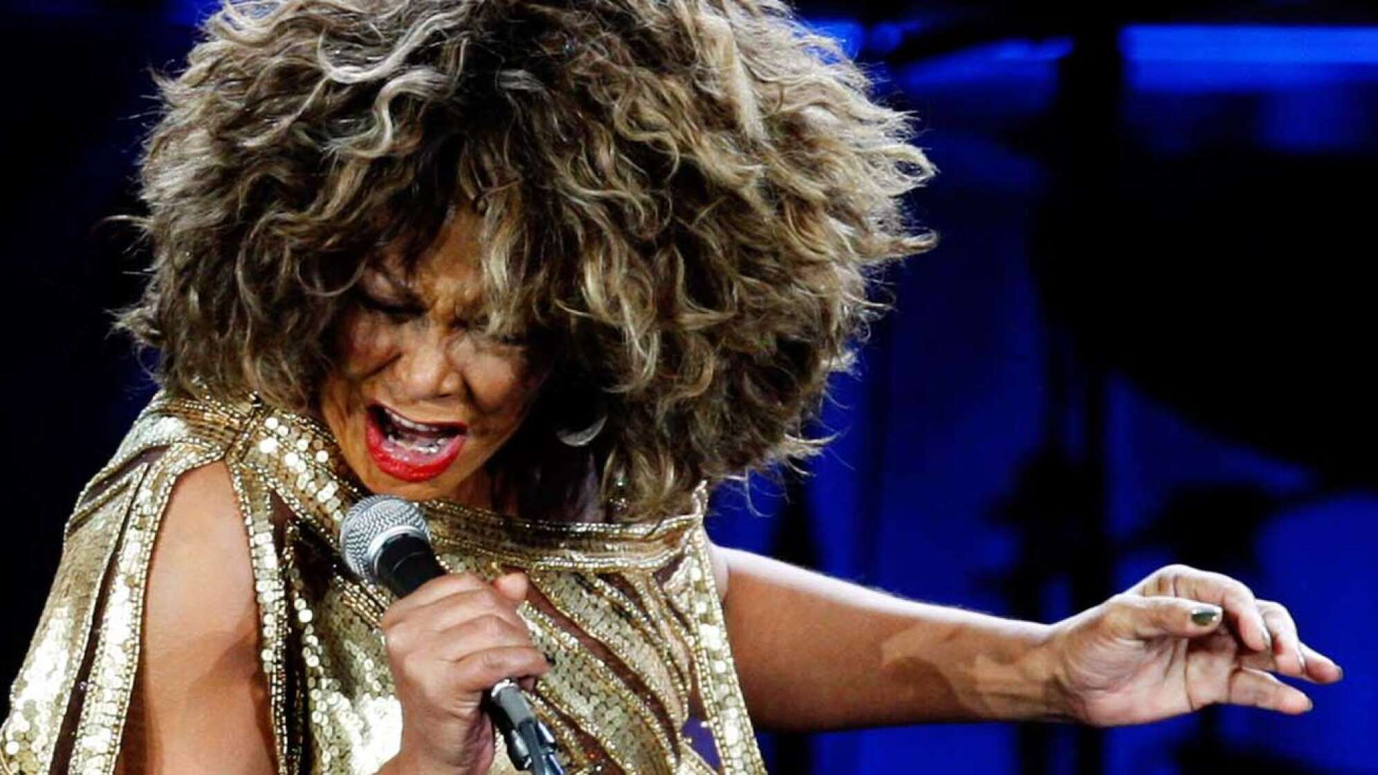Tina Turner singt in ein Mikrofon