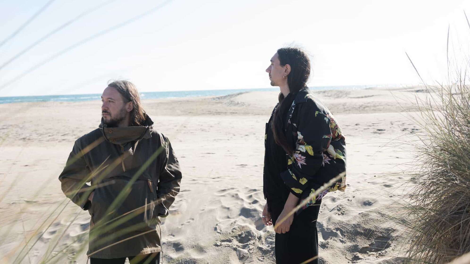 Band Alcest am Strand vor blauem Himmel