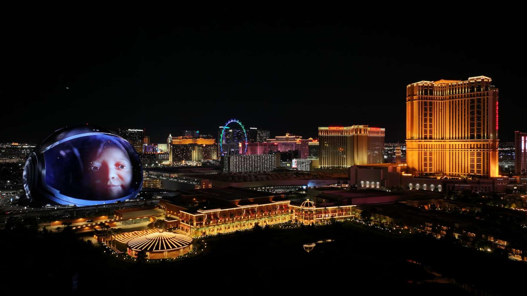Foto des Konzerts von U2 live at The Sphere in Las Vegas, auf dem Bild zu sehen ist der Sphere von außen mit dem Bild eines Babys auf der LED Leinwand, daneben die Skyline von Las Vegas bei Nacht