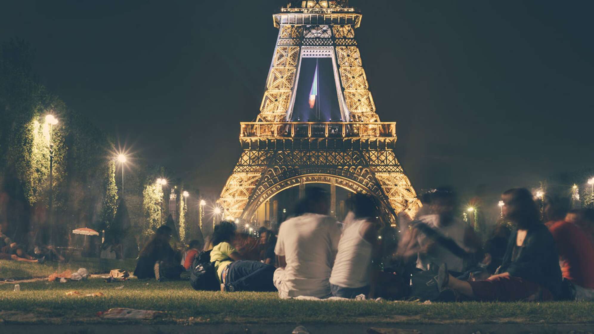 Menschen vor dem Eifelturm in Paris bei Nacht