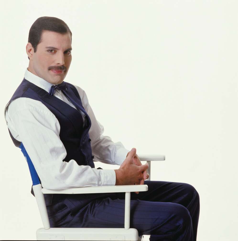 Freddy Mercury sitzt auf einem Stuhl