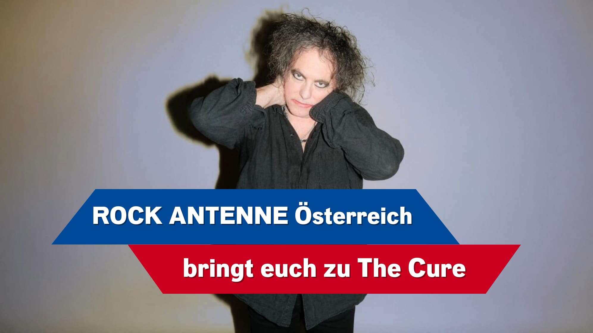 Robert Smith von The Cure vor einem grauen Hintergrund